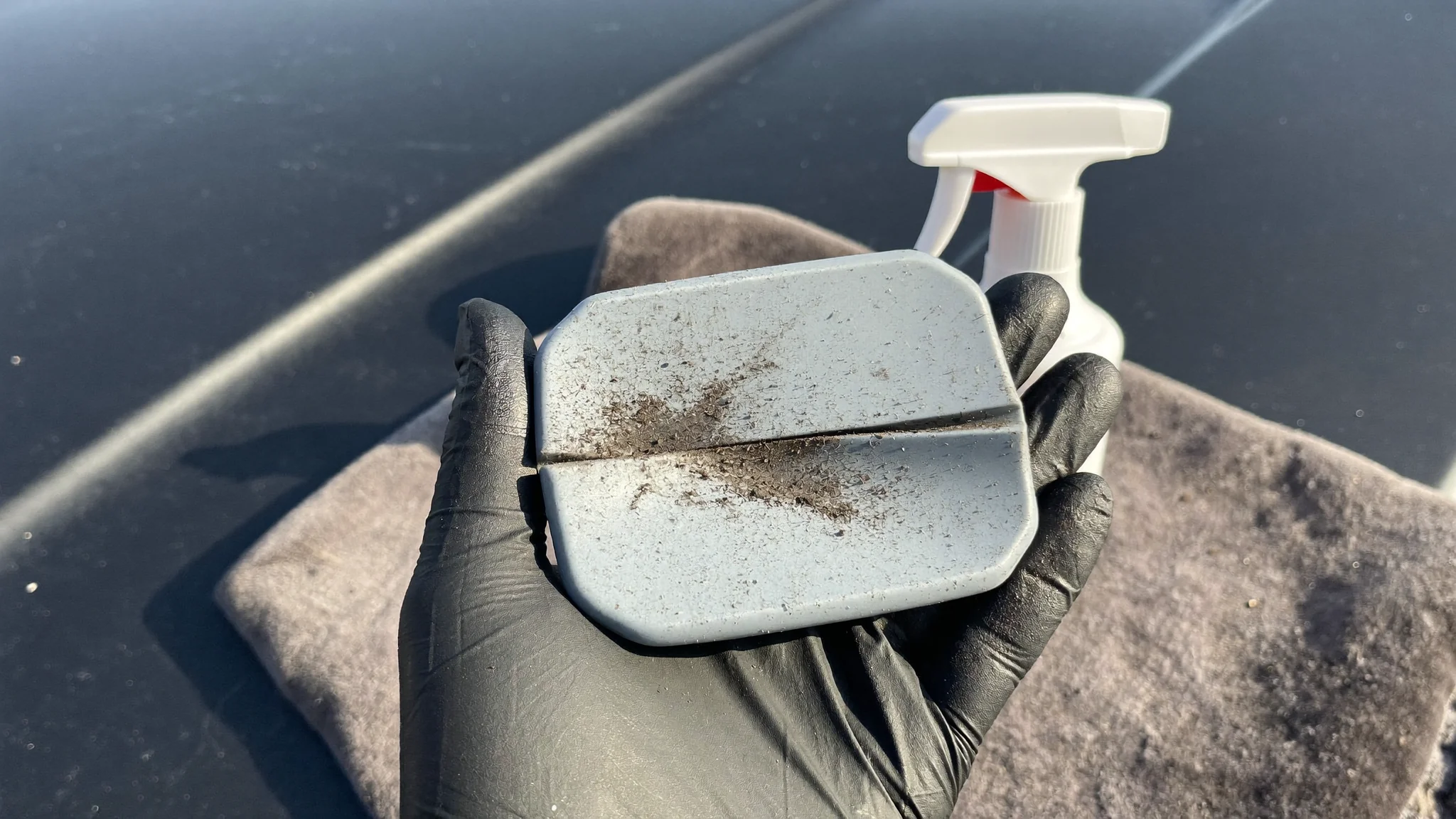 Used detailing clay bar showing grit removed from car paint