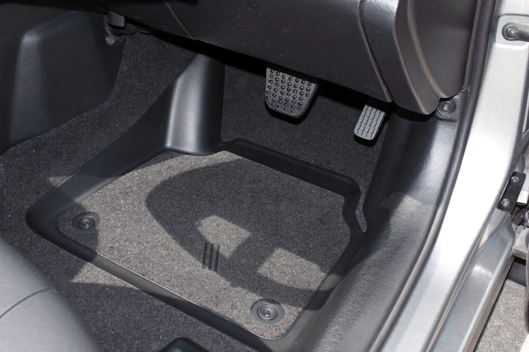 Clean floor mat locked onto the retention post in a driver's footwell
