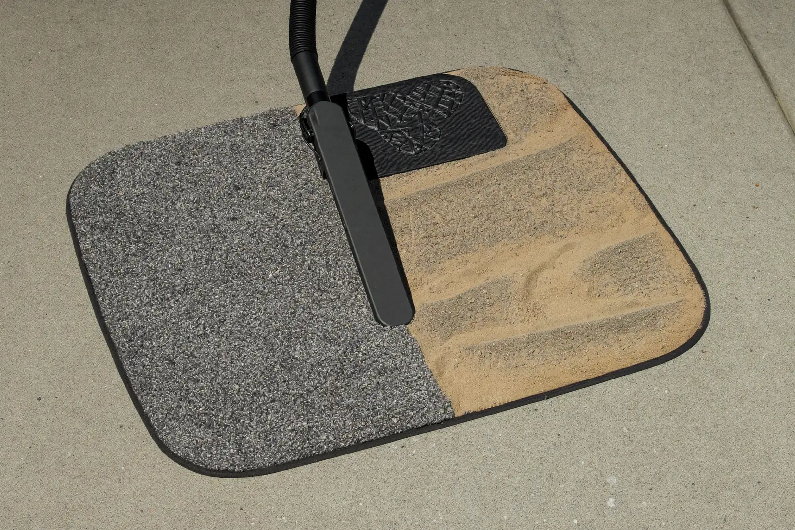 Vacuuming desert sand out of a carpet car floor mat