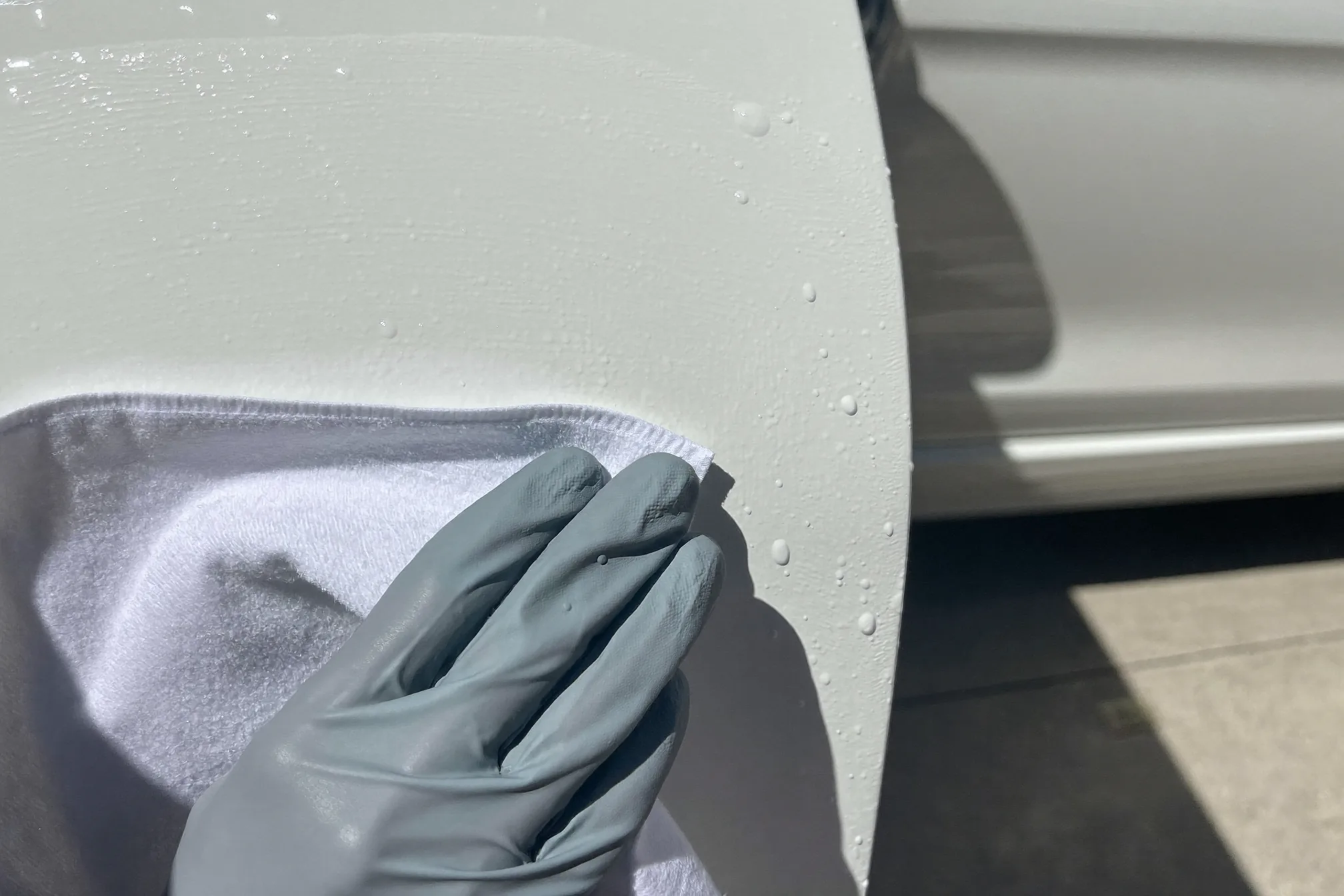 Re-applying wax to a glossy car door panel after tar removal